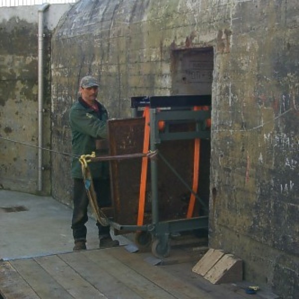 De kraan met deur staat op de vlonder buiten de bunker.