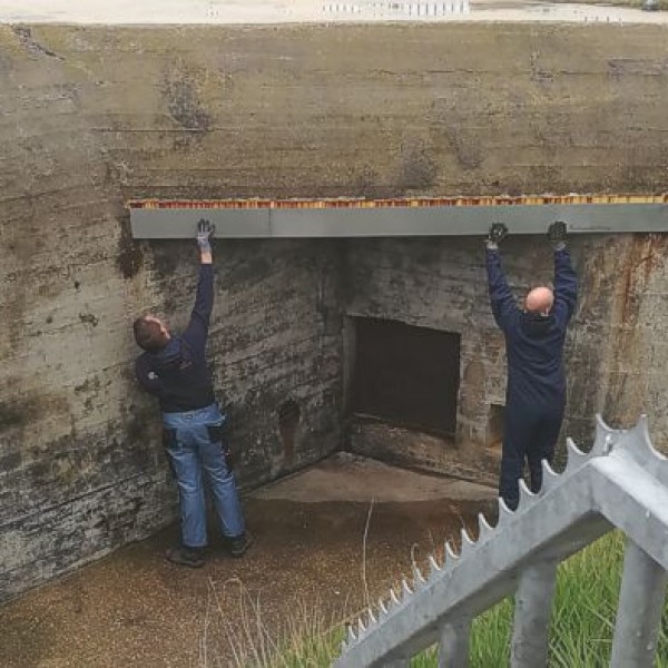Hier wordt gekeken of de nieuwe balk boven de luifel past.